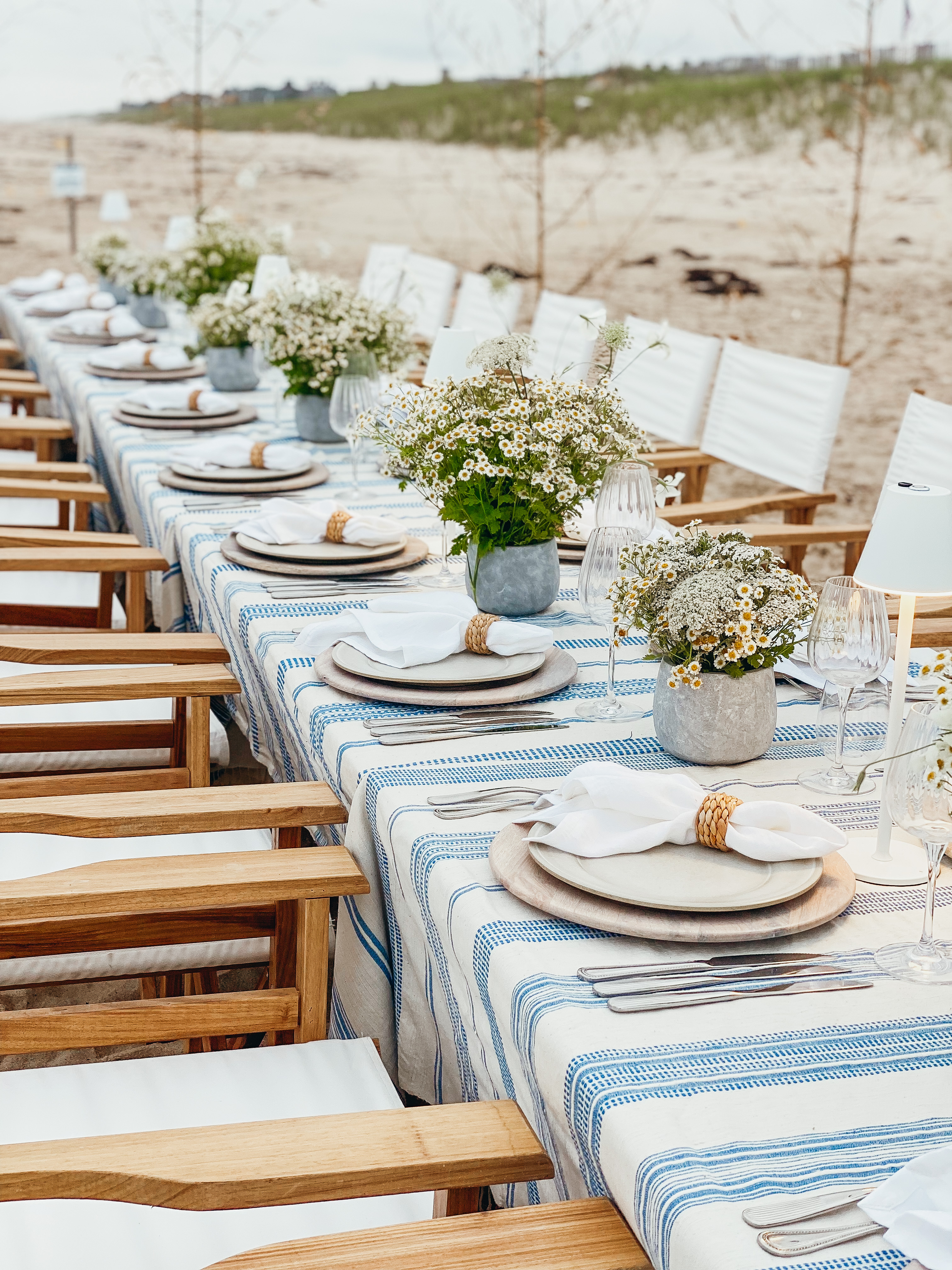 Styled long table with white florals on the beach