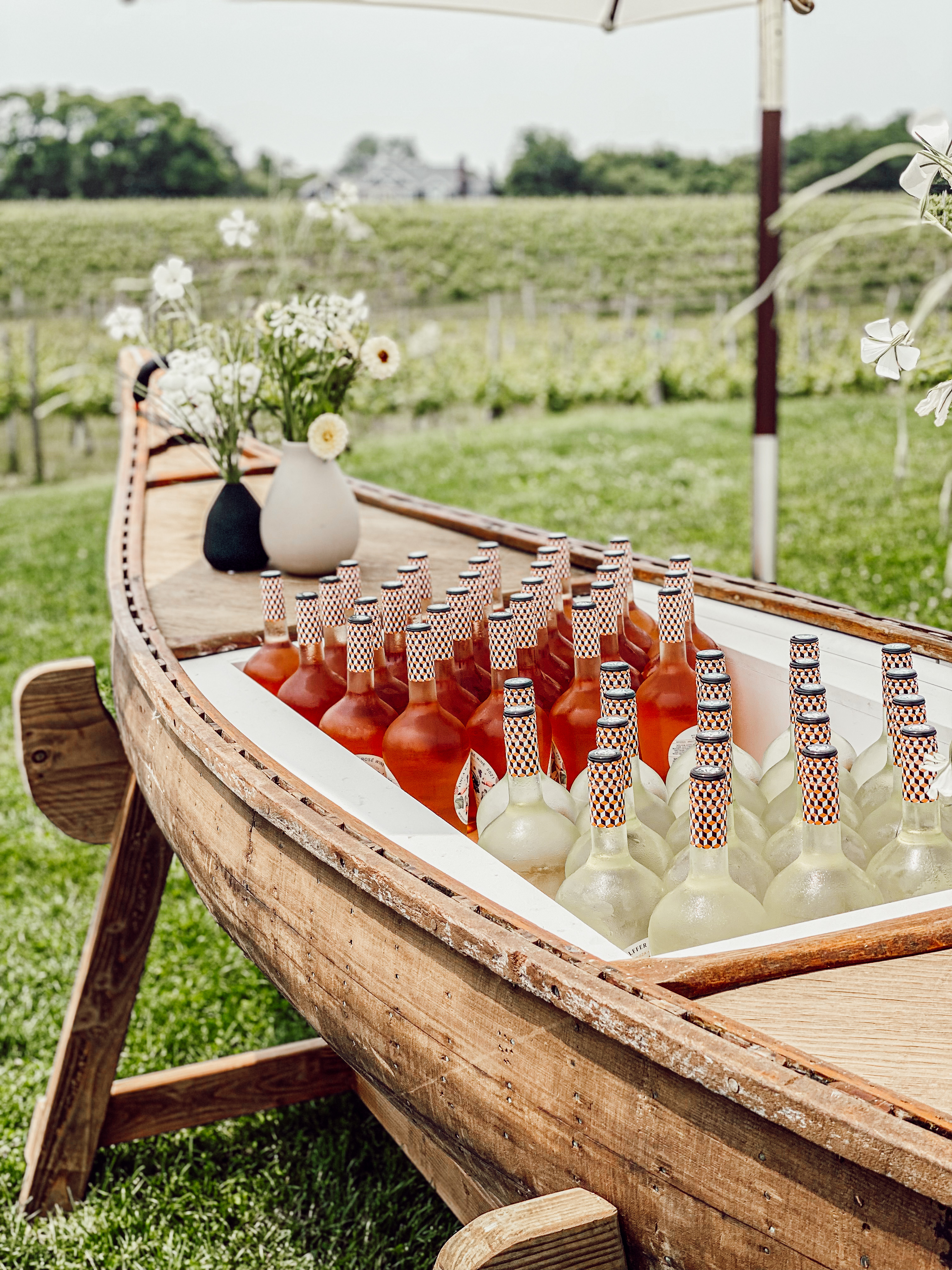 Communal table set on sand with coastal umbrellas