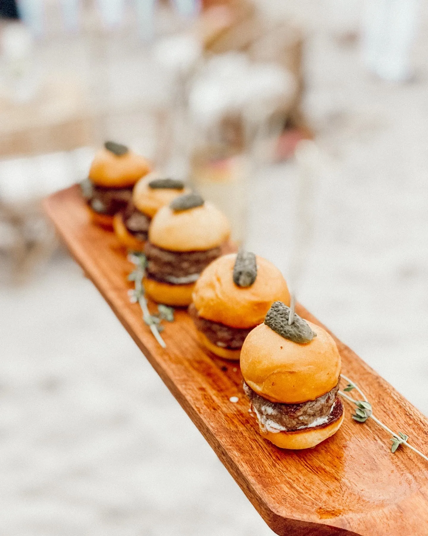 Miniature burgers presented for cocktail hour