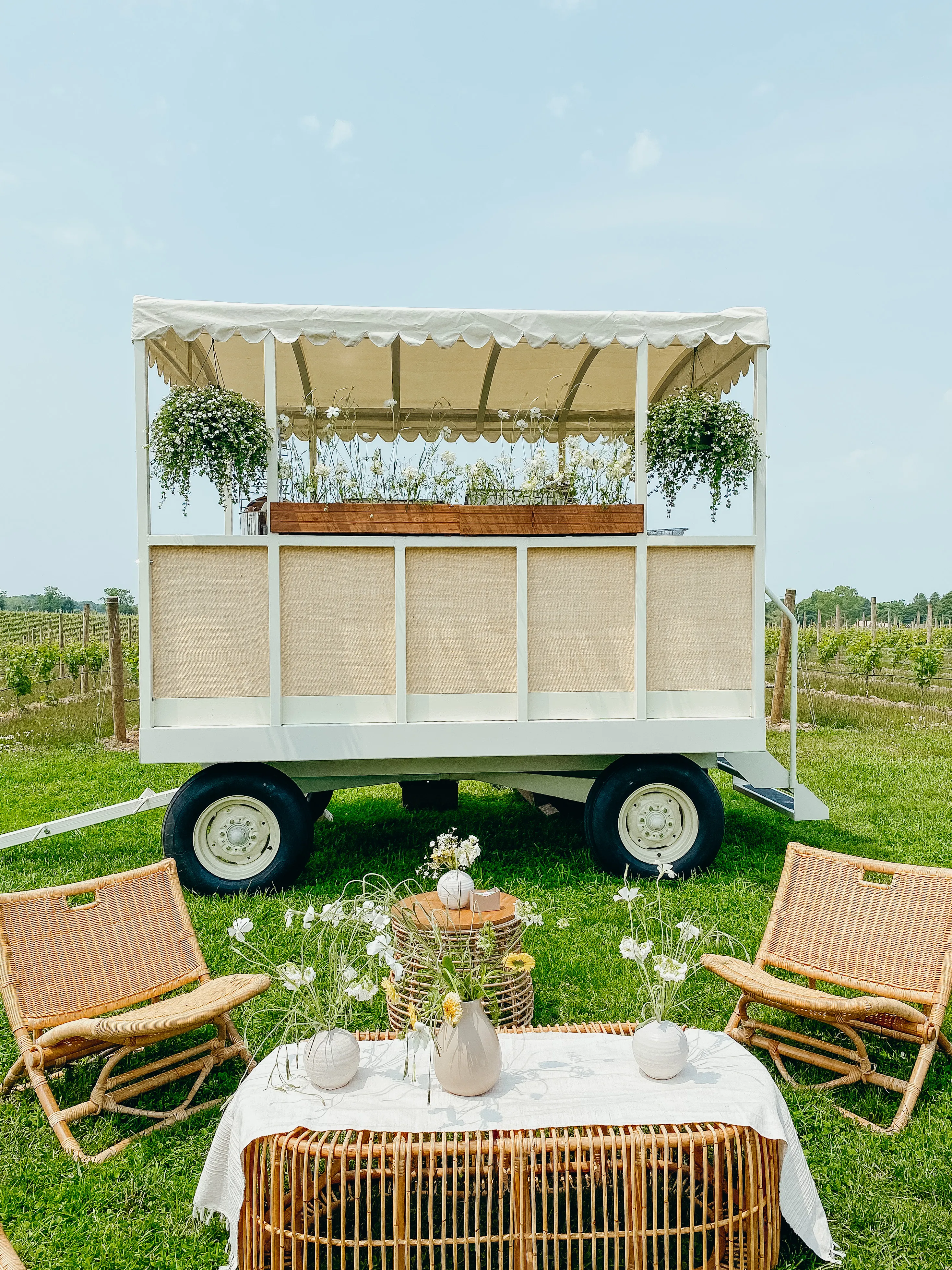 White cart setup in a vineyard with lounge seating